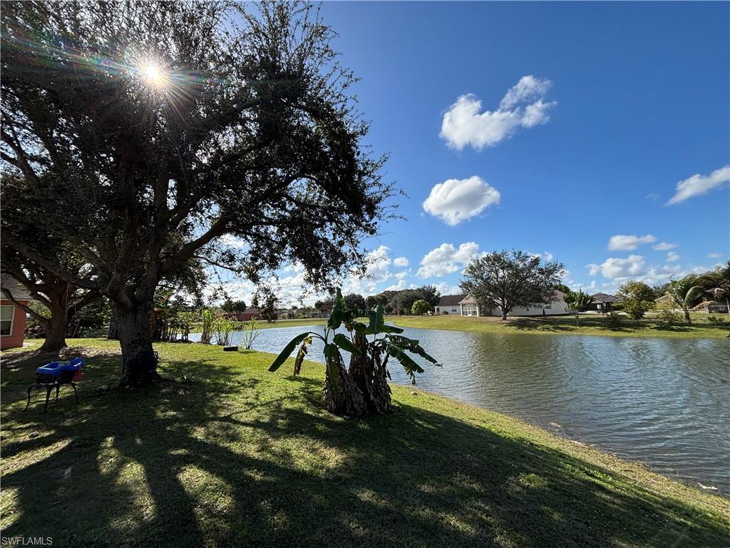 1243 Madison Court Immokalee, FL 34142 - Photo 29 of 32 a view of a lake in between the city and trees