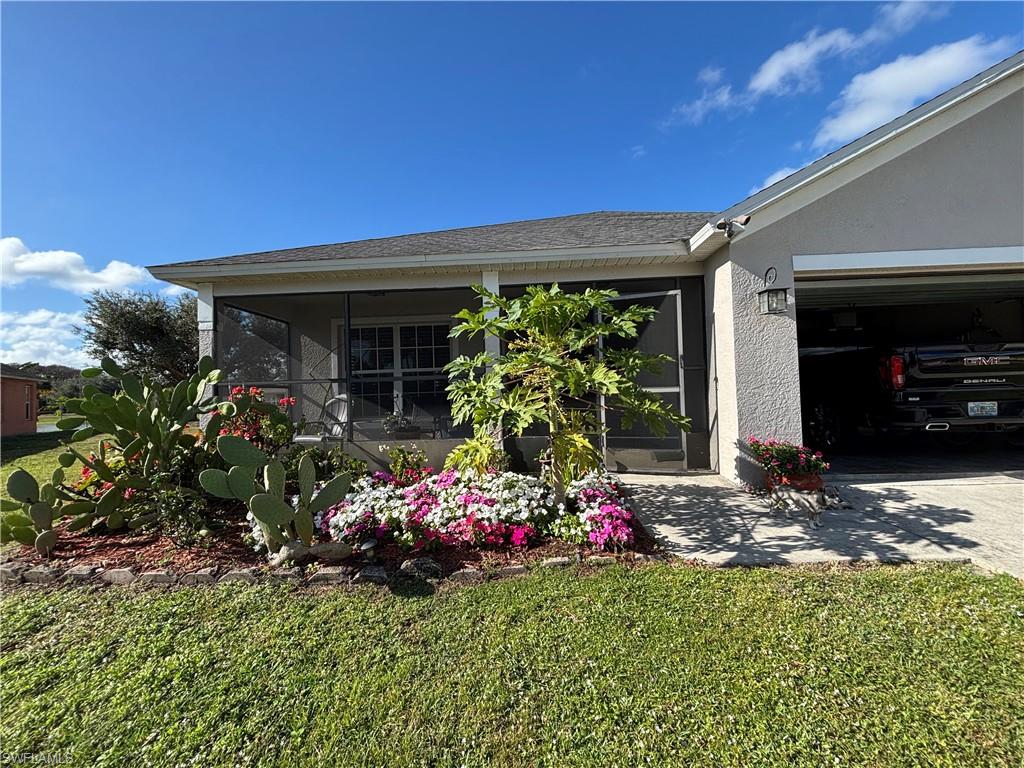 1243 Madison Court Immokalee, FL 34142 - Photo 3 of 32 a front view of a house with a yard