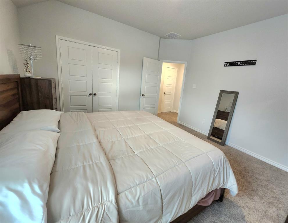 9824 Dynamic Drive Fort Worth, TX 76131 - Photo 12 of 17 a bedroom with a bed and a mirror