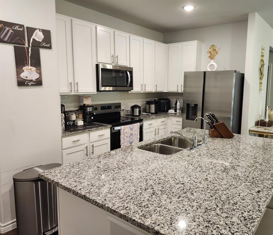 9824 Dynamic Drive Fort Worth, TX 76131 - Photo 7 of 17 a kitchen with stainless steel appliances granite countertop a sink a stove and a refrigerator with wooden floor