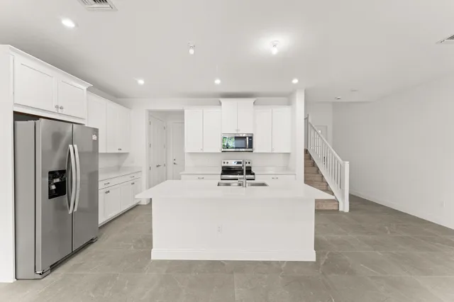 a kitchen with stainless steel appliances a refrigerator sink and cabinets