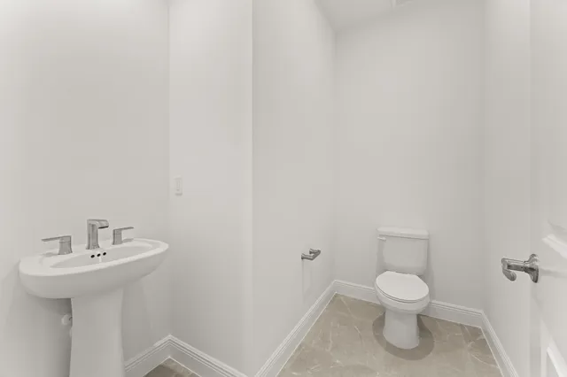 a white toilet sitting next to a white sink