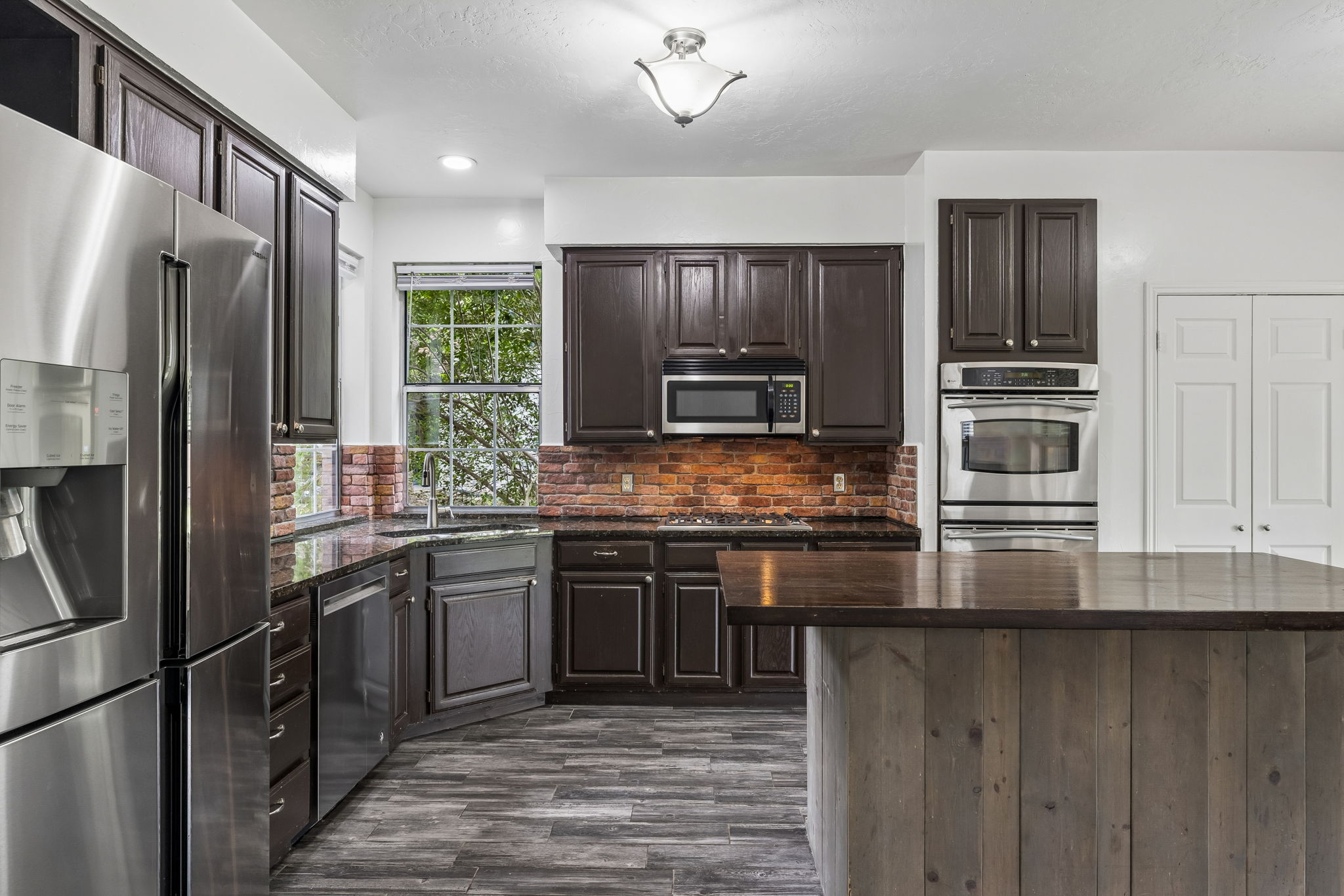 10400 O'Rourk Lane Austin, TX 78739 - Photo 6 of 33 a kitchen with stainless steel appliances granite countertop a refrigerator a stove a sink and a microwave