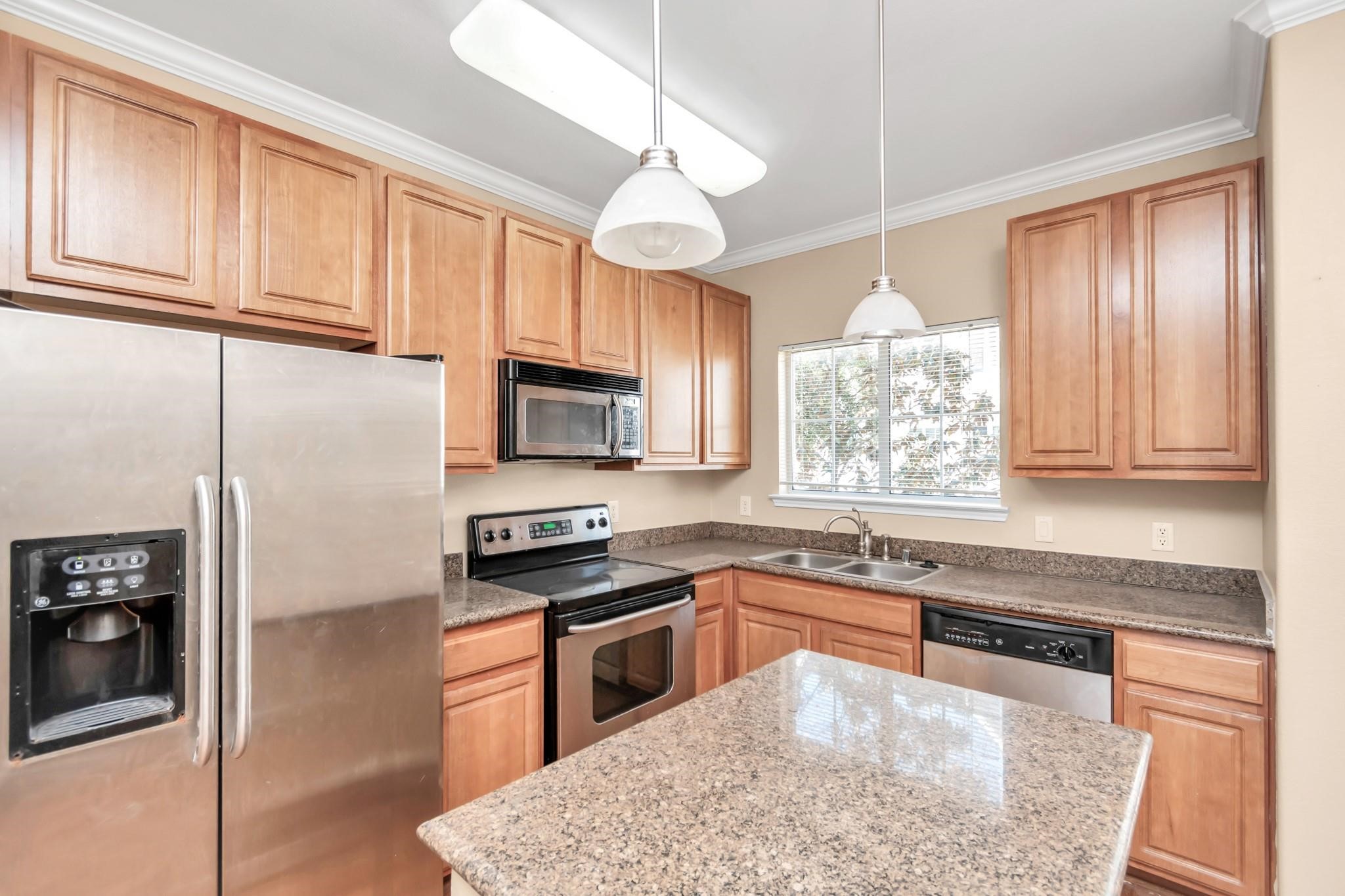 9200 Westheimer Road, Unit 1607 Houston, TX 77063 - Photo 11 of 34 a kitchen with granite countertop a stove a sink and a refrigerator