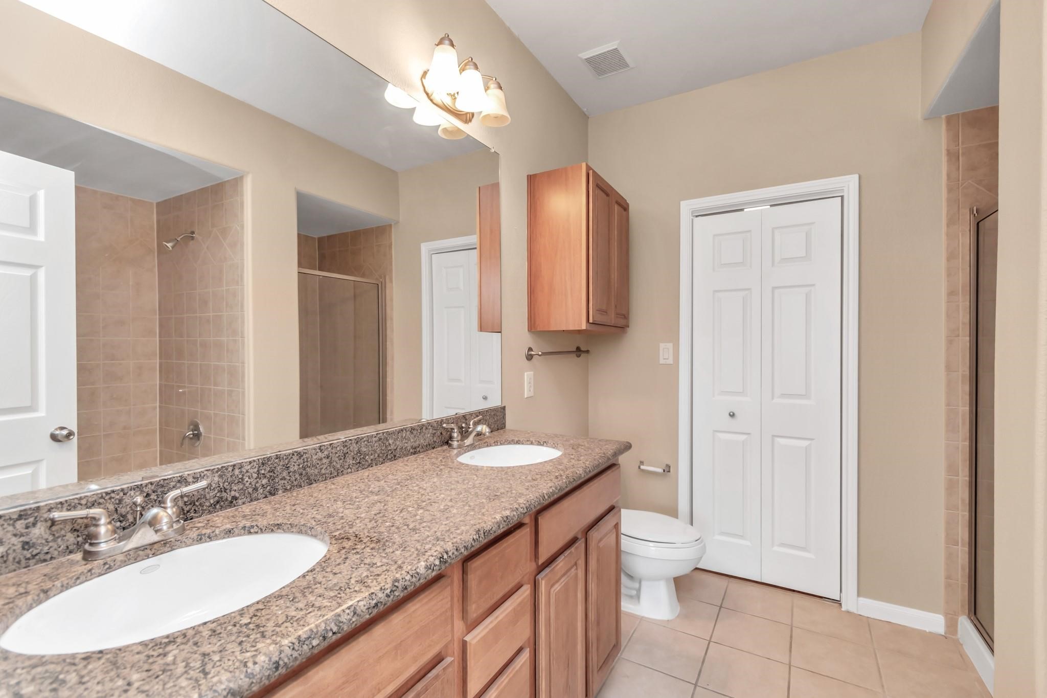 9200 Westheimer Road, Unit 1607 Houston, TX 77063 - Photo 19 of 34 a bathroom with a granite countertop sink toilet and shower