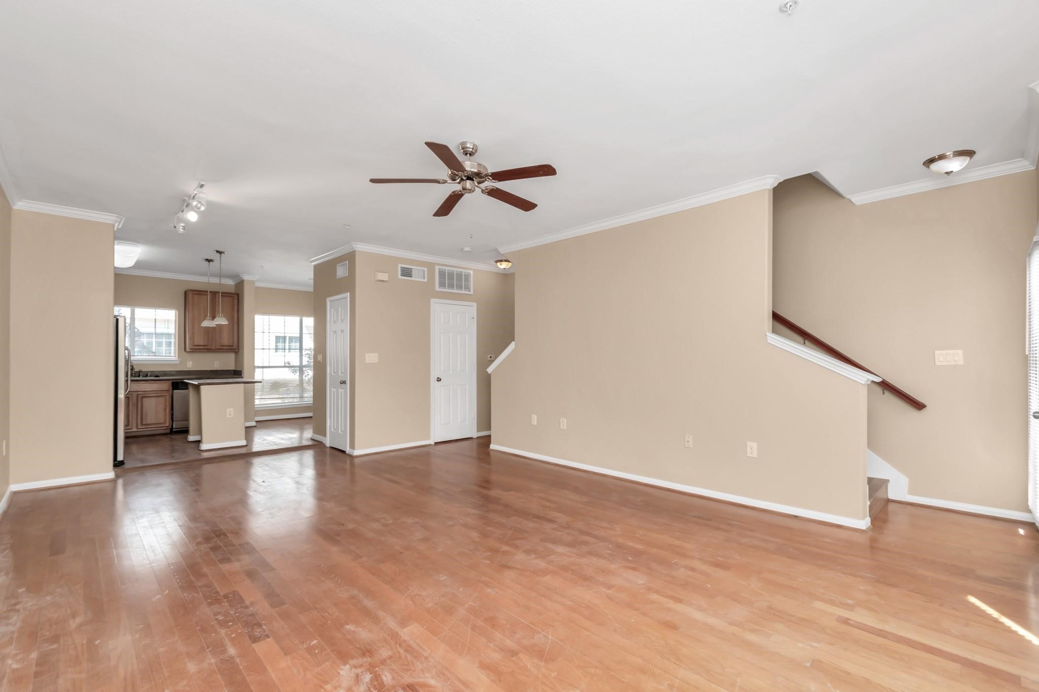 9200 Westheimer Road, Unit 1607 Houston, TX 77063 - Photo 27 of 34 a view of a livingroom with a ceiling fan wooden floor and a kitchen