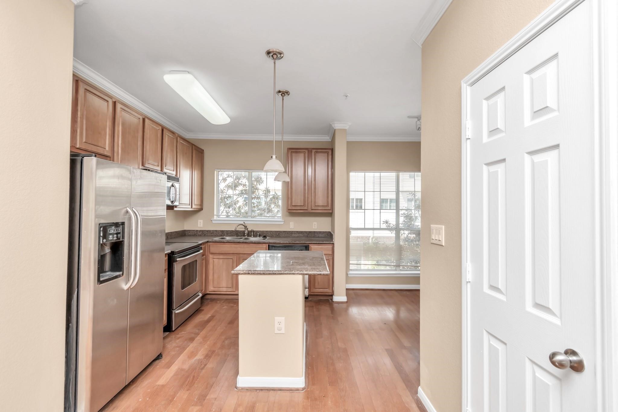 9200 Westheimer Road, Unit 1607 Houston, TX 77063 - Photo 7 of 34 a kitchen with stainless steel appliances granite countertop a refrigerator a sink dishwasher a stove and a dining table with wooden floor