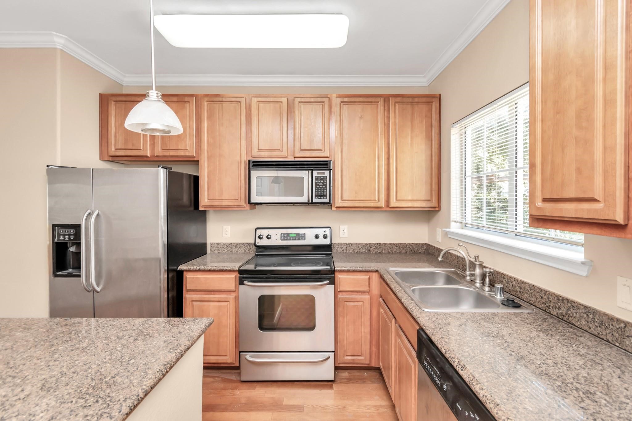 9200 Westheimer Road, Unit 1607 Houston, TX 77063 - Photo 8 of 34 a kitchen with granite countertop a sink stainless steel appliances and cabinets