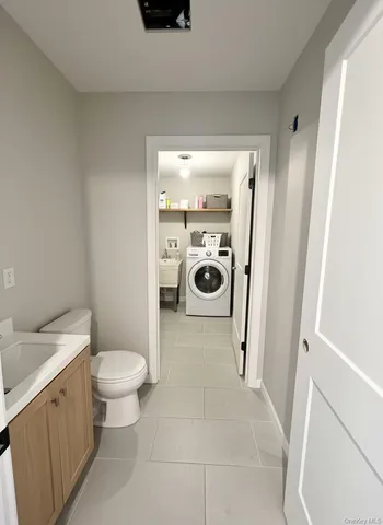 a view of a kitchen with kitchen island a sink wooden floor and a refrigerator