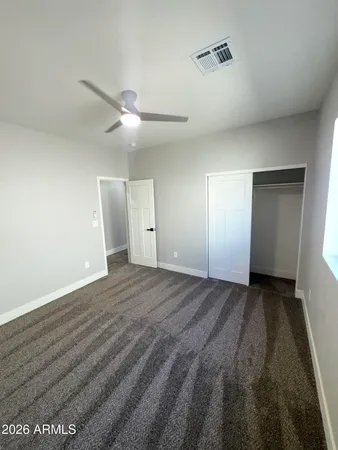 a view of an empty room and a ceiling fan