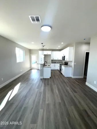 a view of a living room and kitchen with furniture wooden floor and window