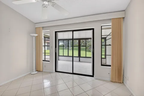 an empty room with windows and ceiling fan