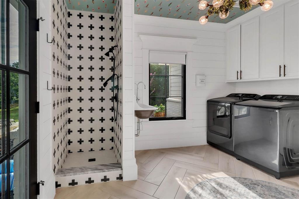 1901 Spring Mountain Road Cross Roads, TX 76227 - Photo 21 of 40 Utility room featuring a tiled shower stall with a black and white cross pattern, a built-in utility sink, and wood-finish herringbone flooring