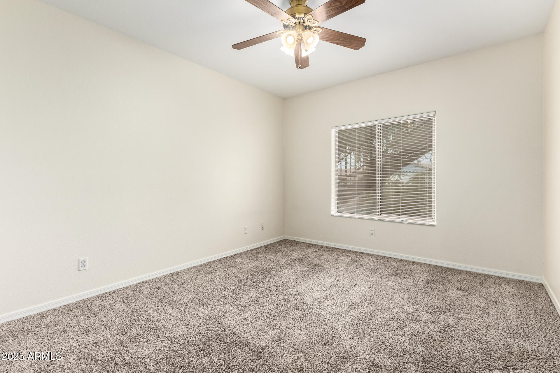 2201 North Comanche Drive, Unit 1104 Chandler, AZ 85224 - Photo 19 of 25 an empty room with a window and a chandelier fan