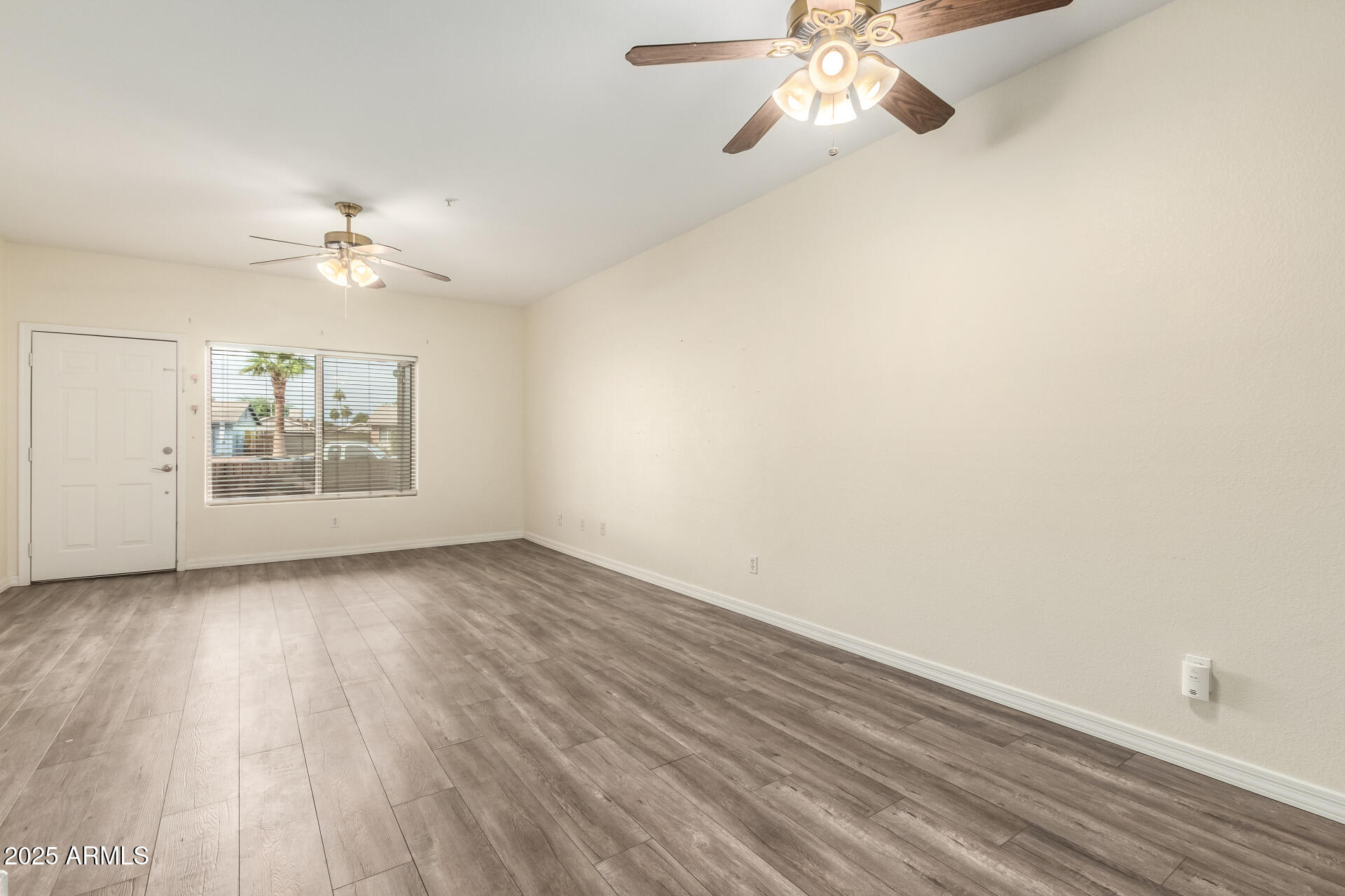 2201 North Comanche Drive, Unit 1104 Chandler, AZ 85224 - Photo 5 of 25 wooden floor in an empty room with a window