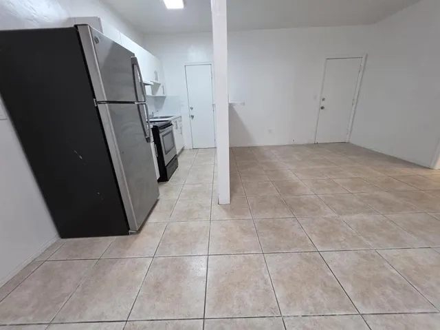 a view of a storage & utility room with a refrigerator