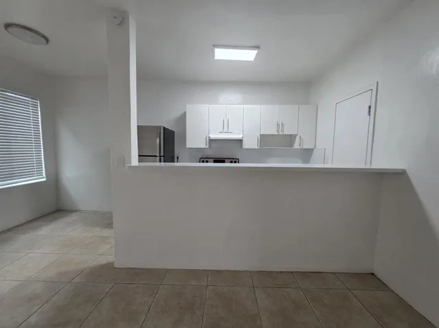 a kitchen with granite countertop a sink and cabinets