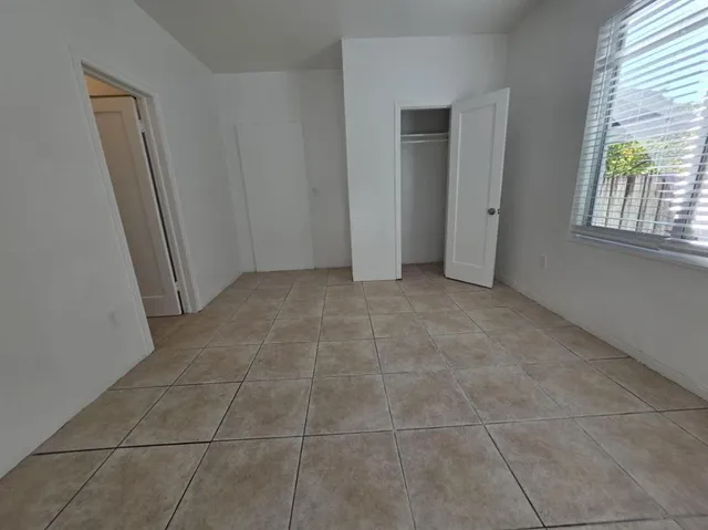 an empty room with windows and closet