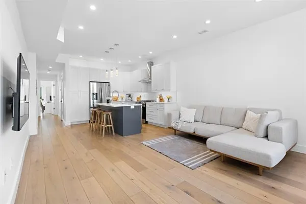 a kitchen with a sink a refrigerator and wooden floor