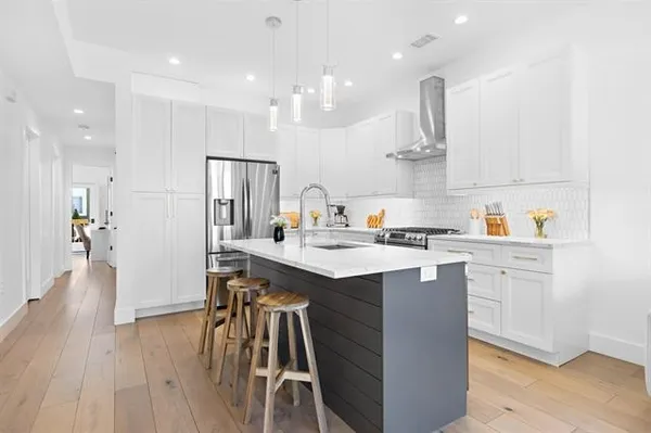 a kitchen with kitchen island granite countertop a sink a counter top space stainless steel appliances and cabinets