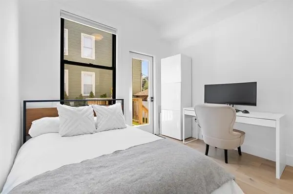 a bedroom with a bed and a large window