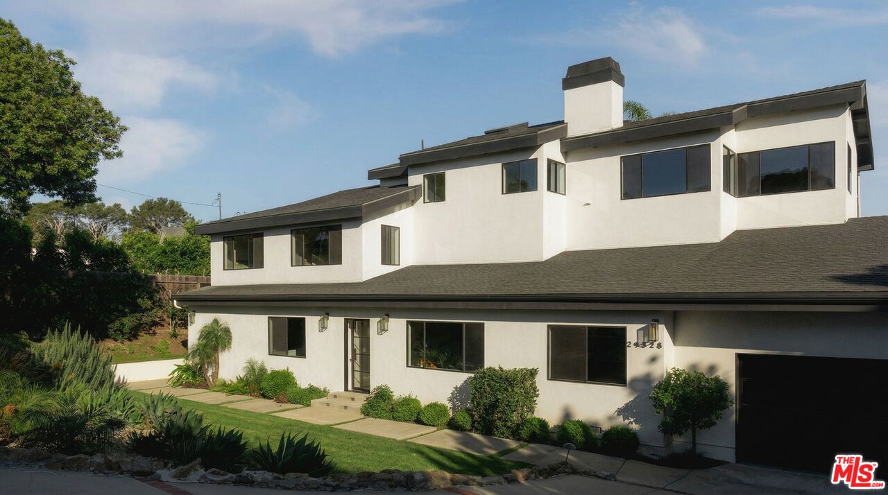 a front view of a house with a yard garage and outdoor seating