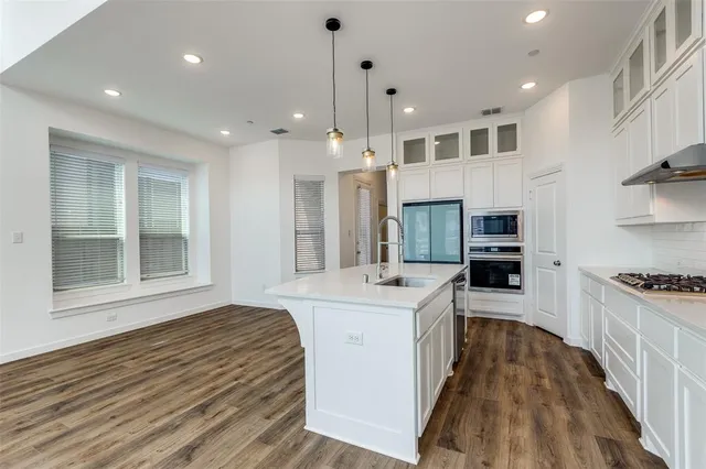 a kitchen with kitchen island a sink stainless steel appliances and cabinets