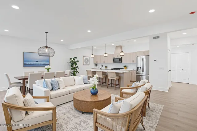 a living room with furniture kitchen and a chandelier