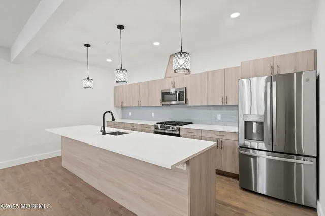 a kitchen with refrigerator cabinets and wooden floor
