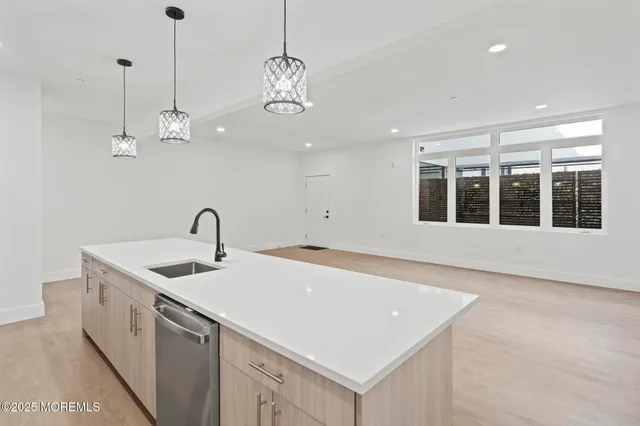 a kitchen with stainless steel appliances granite countertop a sink and dishwasher with white cabinets
