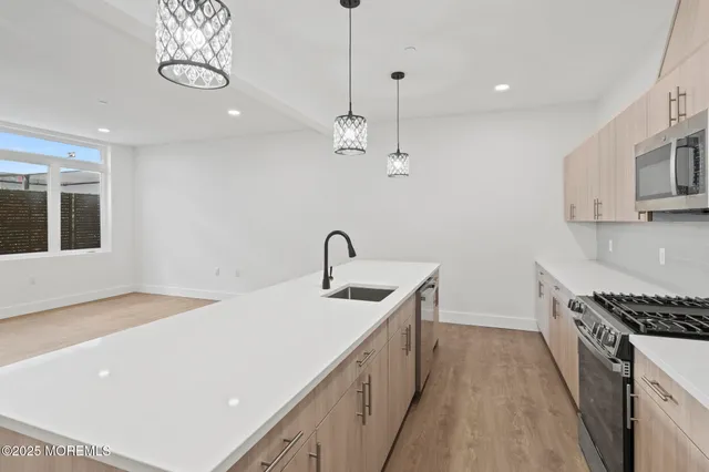 a kitchen that has a lot of cabinets and wooden floor