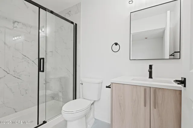 a bathroom with a sink a toilet and shower