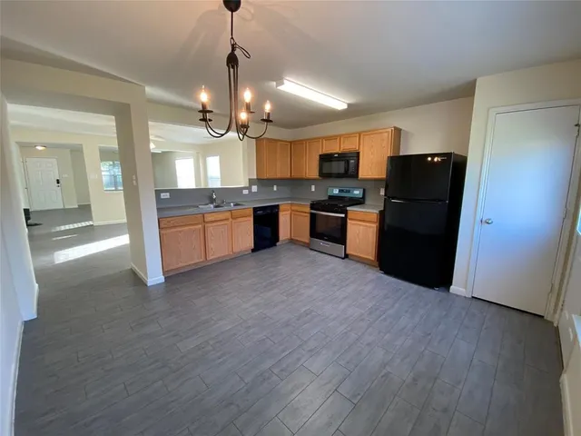 a large kitchen with a wooden floor and a refrigerator