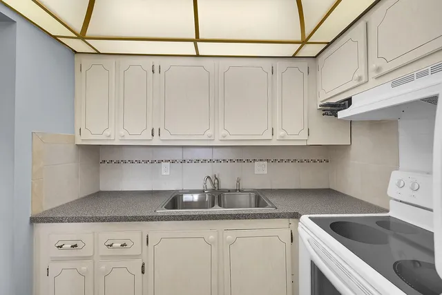 a kitchen with white cabinets and a sink