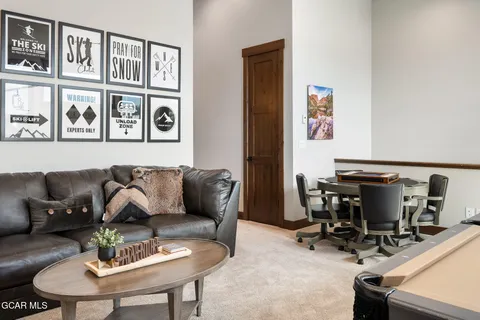 a living room with furniture a clock and a flat screen tv