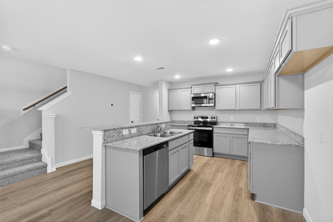 706 Universal Street Navasota, TX 77868 - Photo 16 of 40 a kitchen with stainless steel appliances granite countertop a stove top oven a sink and a refrigerator