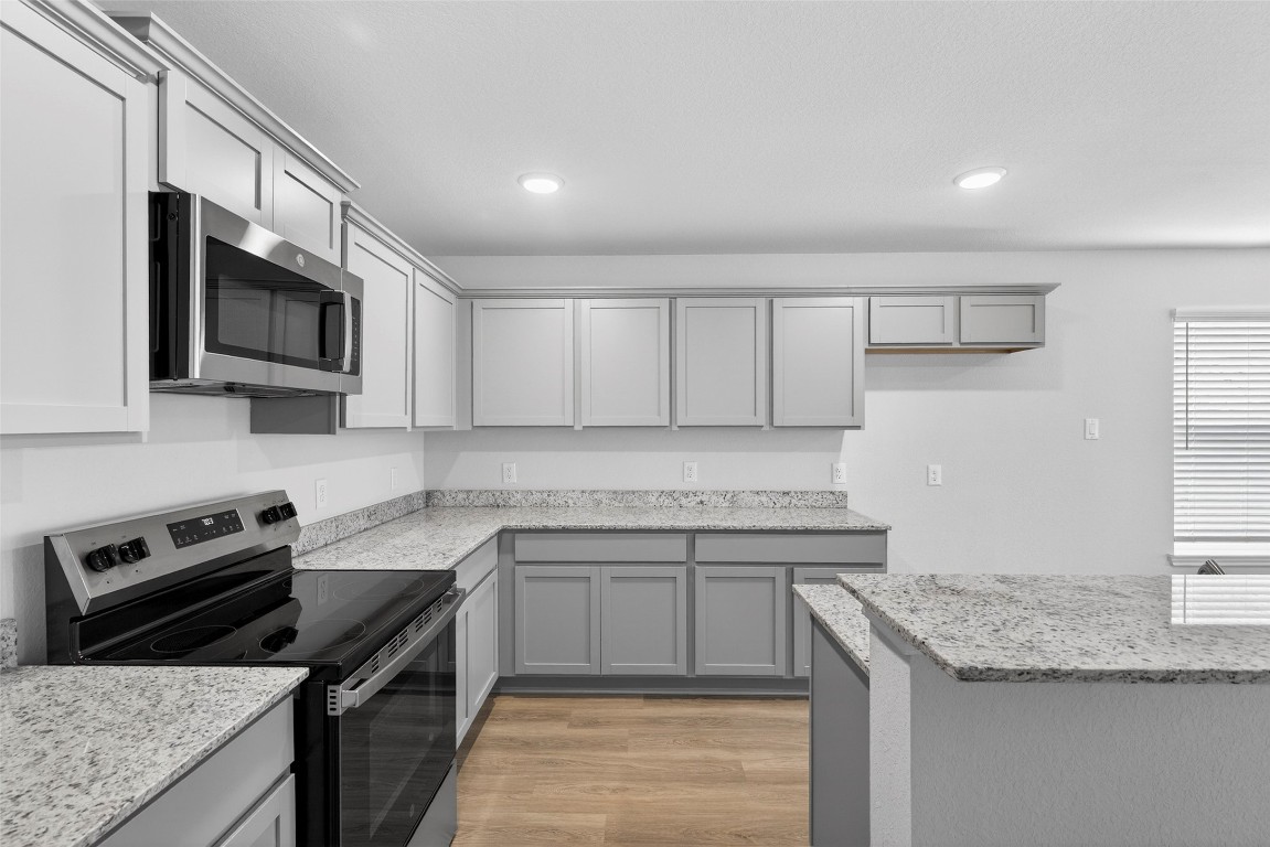 706 Universal Street Navasota, TX 77868 - Photo 7 of 40 a kitchen with stainless steel appliances granite countertop a sink stove microwave and cabinets