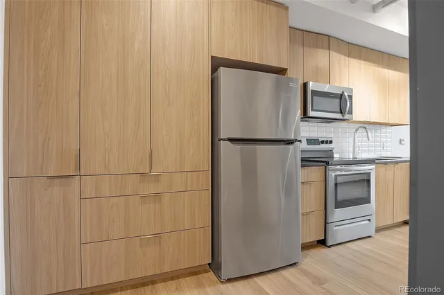 a white refrigerator freezer and a stove sitting inside of a kitchen
