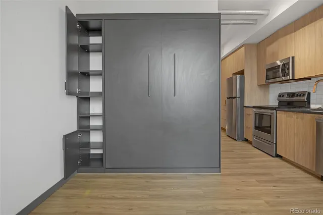 a view of kitchen with stainless steel appliances cabinets and wooden floor