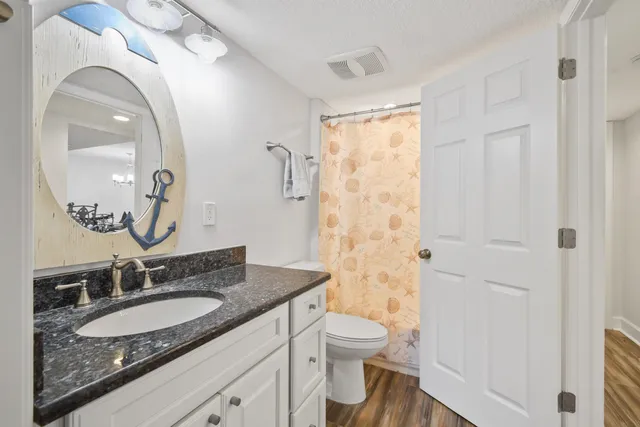 a kitchen with stainless steel appliances granite countertop a refrigerator a stove and a wooden floors