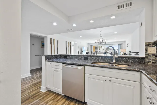 a spacious bedroom with a large bed and a chandelier