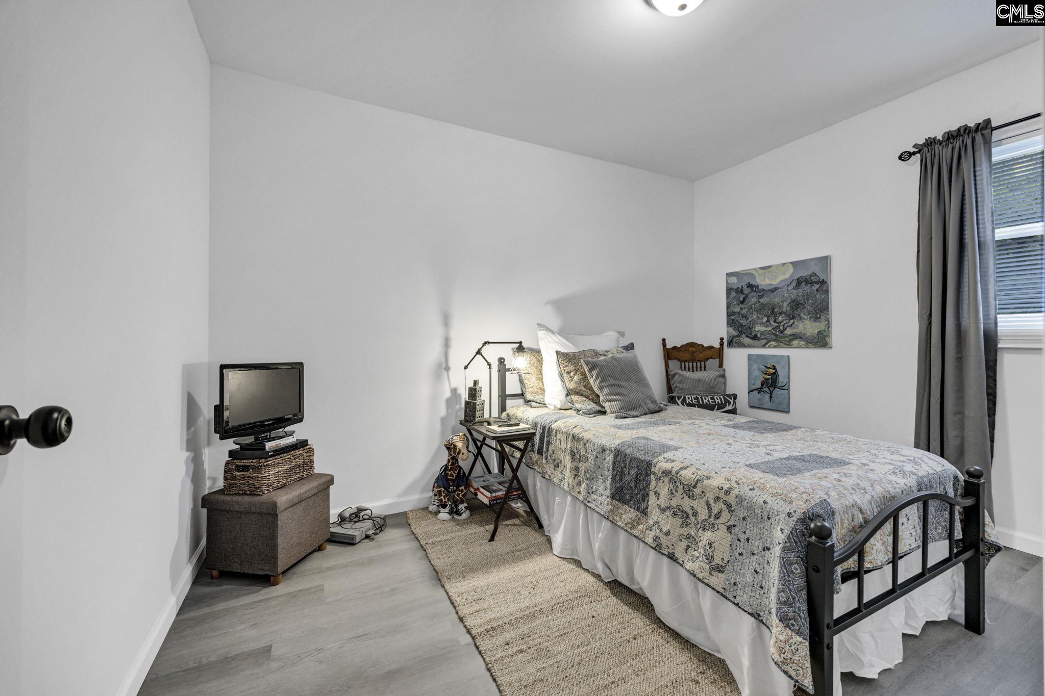 8107 Black River Road Rembert, SC 29128 - Photo 23 of 38 a bedroom with a bed and wooden floor