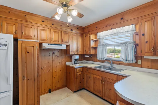 a kitchen with a sink appliances cabinets and a window