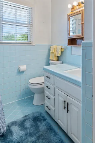 a bathroom with a toilet sink and mirror