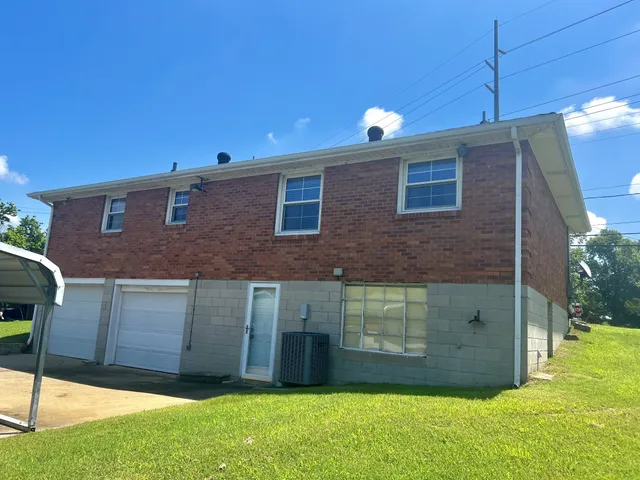 a backyard of a house with plants and outdoor seating
