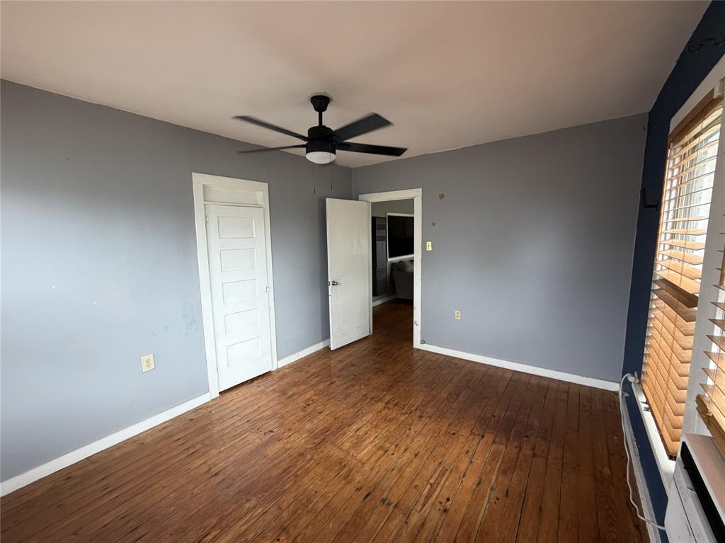 267 North Katy Road Elm Mott, TX 76640 - Photo 7 of 21 Hardwood flooring throughout featuring a ceiling fan with integrated lighting, window with horizontal blinds, and paneled doors