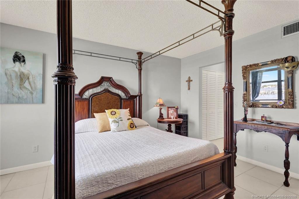 1950 Southwest Palm City Road, Unit 8106 Stuart, FL 34994 - Photo 26 of 54 a bedroom with a bed and a chair