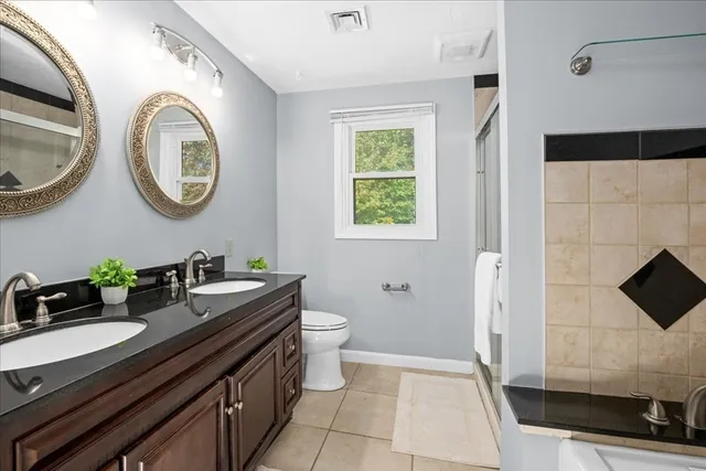 a bathroom with a granite countertop sink a mirror and a bathtub
