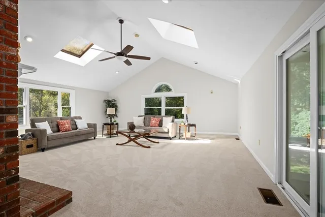 a living room with furniture windows and a ceiling fan