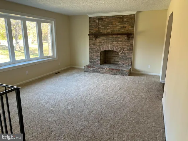 an empty room with fireplace and windows